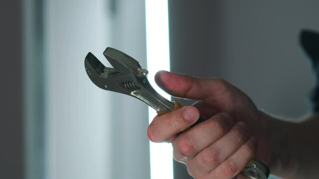 a wrench in the hands of a builder with a circle plan