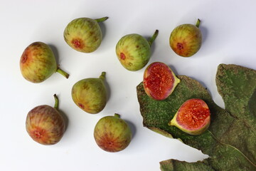 Fresh figs with green leaves on a white background