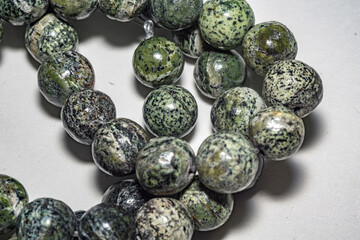 Delicate and charming spotted green serpentine beads, ideal for jewelry, crafts, or decor. Close up...