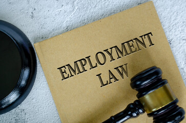 Top view of Employment Law book with gavel on marble background