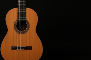Obraz premium Acoustic Guitar Placed Against a Black Background Highlights Craftsmanship and Design Elements