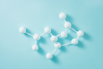Obraz premium A molecular structure model, representing atoms and bonds in a complex molecule. It's displayed on a light blue background.
