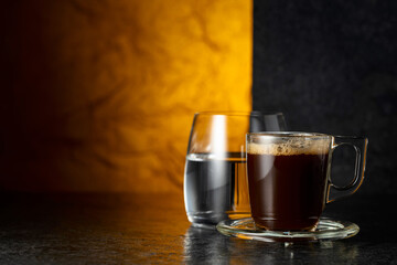 Espresso and glass of cold water on a black background.