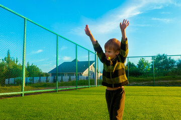The child goes in for sports at the stadium. The boy training before playing football. High quality...