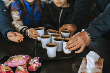 Waiter, server holding tray with paper cups of tea, coffee bringing to wooden table after order....