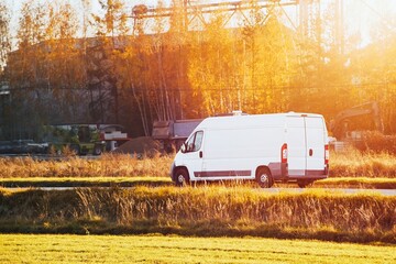 White van driving along autumn landscape