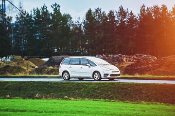 Modern SUV driving along rural road with green scenery