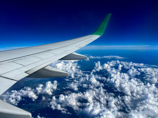 Fototapeta premium view from airplane window with blue sky and white clouds