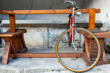 Vintage bicycle parked near wooden bench in rustic outdoor setting