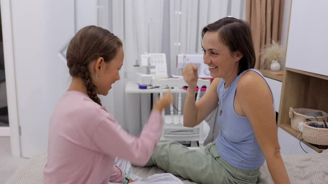 Mother and daughter sit on a bed in a room and play the game rock, paper, scissors. Great for themes of family, bonding, and home activities. https://gptonline.ai/ru/