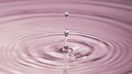 Ephemeral Echo: A single droplet, captured mid-air, creates a mesmerizing ripple effect on a smooth surface. The image evokes tranquility and the fleeting beauty of nature.