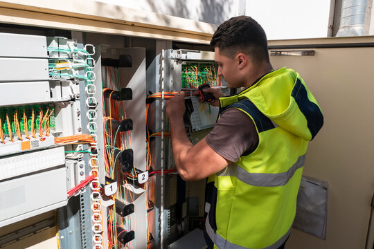 T&eacute;cnico de fibra &oacute;tica a realizar reparo num arm&aacute;rio para restaurar o acesso &agrave; rede de clientes afetados por avaria