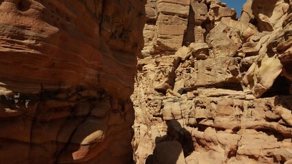 Narrow canyon with towering red rock walls under sunlight