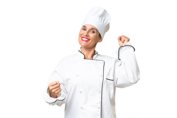 Middle-aged chef woman over isolated background celebrating a victory