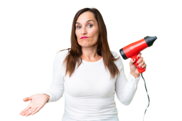 Middle age woman holding a hairdryer over isolated chroma key background making doubts gesture while lifting the shoulders