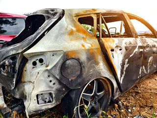 Charred remnants of a vehicle interior left behind after a devastating fire incident