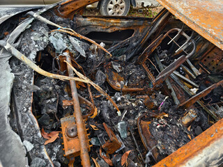 Charred remnants of a vehicle interior left behind after a devastating fire incident