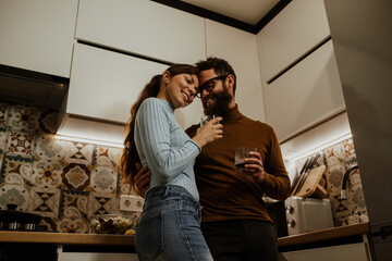 An elegant couple, around 35 years old, is enjoying a cozy evening together.