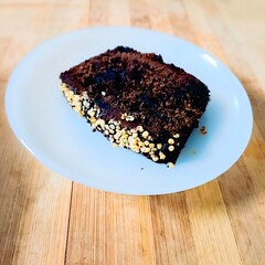Moist and rich chocolate cake with a golden crust of hemp hearts, blending indulgence with a nutritious crunch.