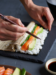 Chef's hands preparing sushi