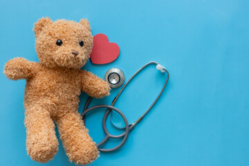 close up teddy bear as paediatrician with stethoscope and heart  on blue color background for representative of medical as kid and childhood concept