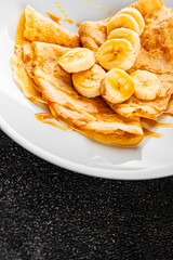 Crepes banana syrup pancakes breakfast dish dessert organic product fresh tasty gourmet food background on the table rustic food top view copy space