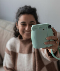 Smiling girl takes a selfie with an analog camera