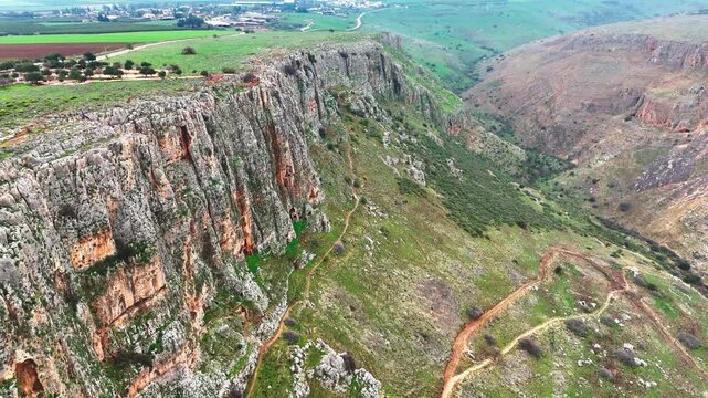 Aerial view of Mount Arbel overlooking the Sea of Galilee. Captured by drone, this breathtaking landscape showcases the dramatic cliffs of Arbel, lush valleys, and the sparkling waters of Lake Kinnere