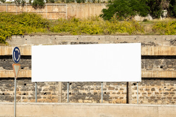 A prominent white billboard stands against the vibrant backdrop of Funchal's bustling streets.