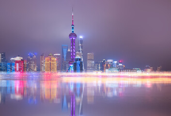 Shanghai colorful skyline with motion speed light of passing ferry in the foreground at night - Shanghai, China