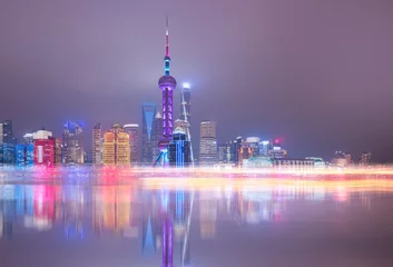 Fototapeten Shanghai colorful skyline with motion speed light of passing ferry in the foreground at night - Shanghai, China © muratart