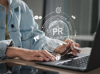 Businessman using laptop with public relations on virtual screen for marketing strategy, public...