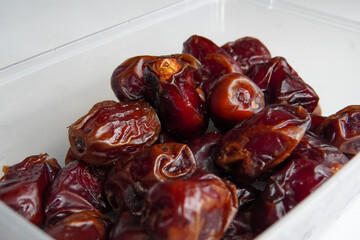 a pile of dates in a plastic box isolated white background