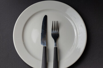 Empty white plate with fork and knife