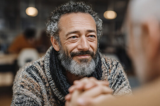 Middle Aged Man Smiling Warmly During Conversation Indoors