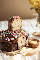 Colomba is a traditional Italian Easter cake, Colomba pasquale, colomba di Pasqua, an analogue of panettone and pandoro. Colomba in section with chocolate drops on a light background, flowers nearby.