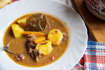 Veal stew,veal soup with potatoes on a wooden table.