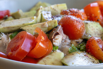 Tomatoes, avocado, and smoked mackerel drizzled with olive oil, a healthy, ketogenic dish rich in omega-3 fatty acids, micronutrients, and healthy fats.