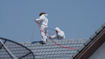 Professional painter on roof Working at heights is dangerous.