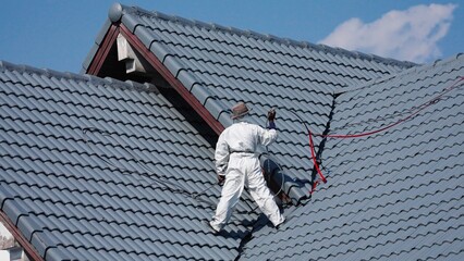 Professional painter on roof   Working at heights is dangerous.