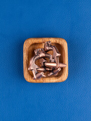 Close up of a metal maze puzzle on a blue background