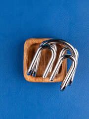 Close up of a metal maze puzzle on a blue background