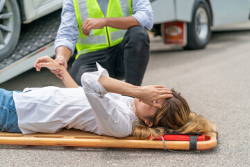 agent help injured woman using stretcher from car accident in asia countryside. asian woman in pain lifting by stretcher. unconscious woman lying got rescue from emergency officer from vehicle crash