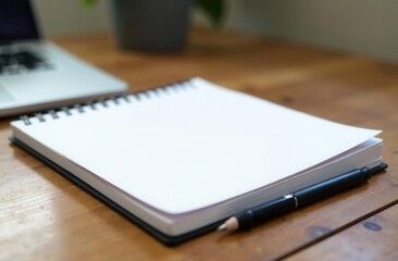 Open notebook and pencil on wooden desk near laptop