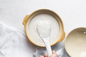 Top view of plain rice porridge in a ceramic spoon