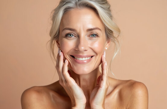 Smiling senior woman touches face, applying peeling lifting product beauty spa offer. Flawless skin, healthy appearance. Elegant mature female, perfect face, gentle touch, cosmetology.