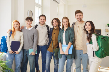 Group portrait of happy diverse friends, interns, students after successfully passes school, college exam, young business project team of employees holding paper documents, looking at camera, smiling 