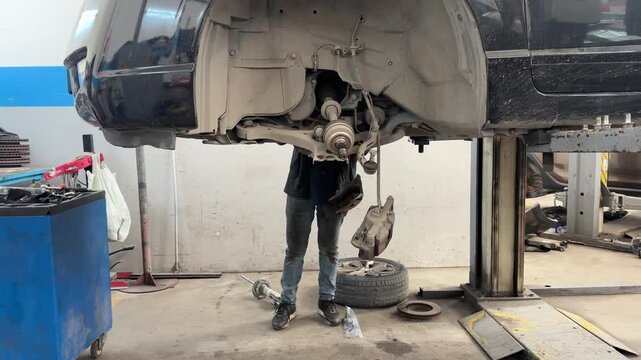 A technician is repairing the shock absorber section of the car.