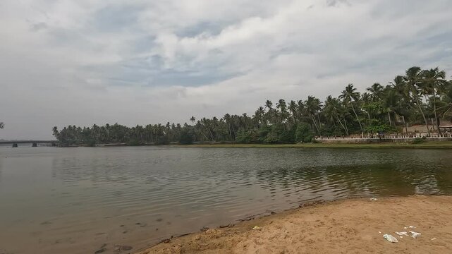 Freshwater lake meets the sea at Kappil Beach near Varkala, India against a cloudy skies, tropical nature, and rare coastal serenity in one scenic view.