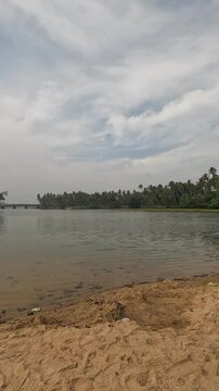 Freshwater lake meets the sea at Kappil Beach near Varkala, India - against cloudy skies, tropical nature, 